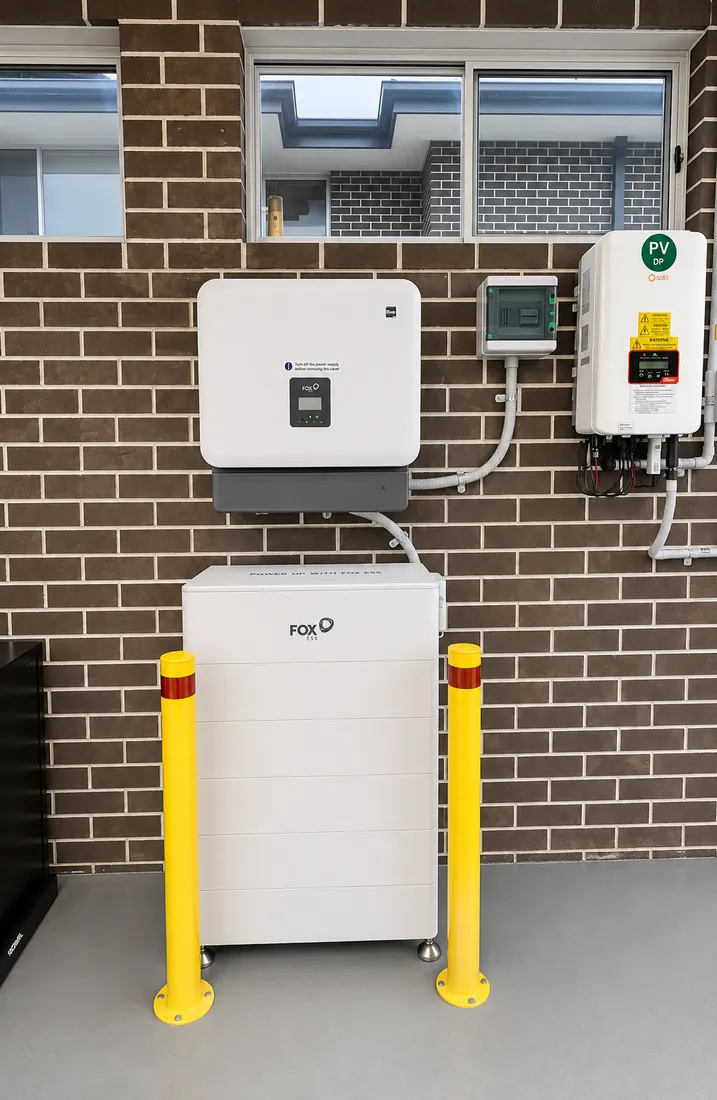 FoxESS battery and hybrid inverter installed on a brick garage wall